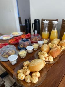 a table topped with plates of food and bottles of orange juice at Pousada Tabernáculo in Tiradentes