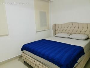 a bed in a white room with a blue blanket at Denize sıfır benzersiz villa in Kusadası