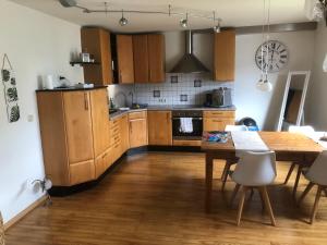 a kitchen with wooden cabinets and a table with chairs at FeWo Annabell in Sankt Wendel