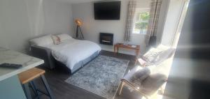 Kleines Zimmer mit einem Bett, einem Sofa und einem TV in der Unterkunft Country Cottage Barn Conversion in Pollington