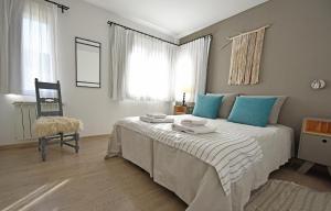Un dormitorio con una cama con almohadas azules y una silla en Cuesta de los Andes By Visionnaire en San Martín de los Andes