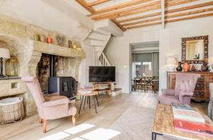 Il comprend un salon doté d'une cheminée en pierre et d'une télévision. dans l'établissement Maison de charme Beaumont, proche Deauville, à Beaumont-en-Auge
