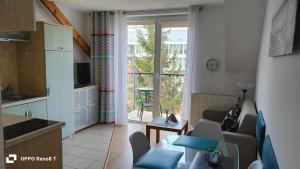 eine Küche und ein Wohnzimmer mit einem Sofa und einem Tisch in der Unterkunft Apartament za wydmą Sosnowa 13 in Mielno