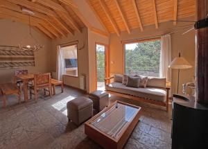 - un salon avec un canapé et une table dans l'établissement Rosas Blancas Apart Hotel By Visionnaire, à San Martín de los Andes