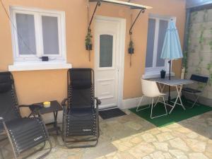 Chez Simina في Vaires-sur-Marne: غرفة بها كراسي وطاولة ومظلة