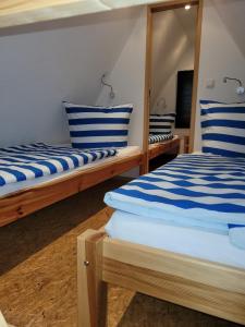 2 Betten mit blau und weiß gestreiften Kissen in einem Zimmer in der Unterkunft Finndorf am Strand in Trassenheide