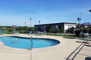 - une piscine avec des chaises, des tables et des parasols dans l'établissement Quality Inn Austintown-Youngstown West, à Youngstown