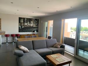 a living room with a couch and a table at Penthouse Apartment mit Alpenblick in Friedrichshafen