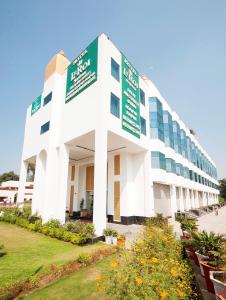 a white building with green and white signs on it at Hotel Le Roi,Haridwar@Har Ki Pauri in Haridwār