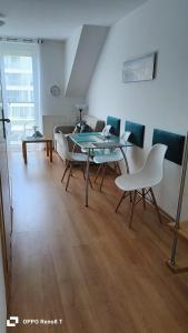 ein Wohnzimmer mit einem Tisch, Stühlen und einem Sofa in der Unterkunft Apartament za wydmą Sosnowa 13 in Mielno