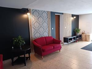 a living room with a red chair and a table at Smrek Sokolec Agroturystyka in Ludwikowice Kłodzkie +43 photos