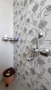 a bathroom with a shower with a floral shower curtain at A Homely 2 BHK in Main Kharadi - Anandkunj in Pune