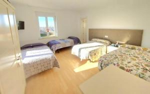 Villanueva de las ManzanasにあるCasa Miguel & Sallyのベッド4台と窓が備わる客室です。