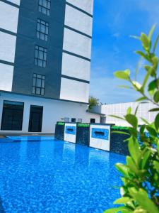 una piscina blu di fronte a un edificio di Remas Hotel Hatyai a Hat Yai