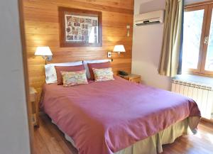 a bedroom with a large bed with two pillows at Cabañas Las Pampas by Visionnaire in San Martín de los Andes