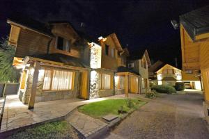 una casa por la noche con luces en el garaje en Cabañas Las Pampas by Visionnaire en San Martín de los Andes