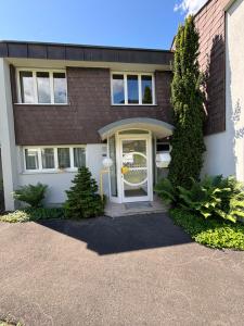 a brick house with a white door and aphalt driveway at Garden Park Apartment in Interlaken