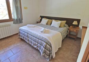 a bedroom with a large bed with two pillows at Cabañas Humo Azul by Visionnaire in San Martín de los Andes