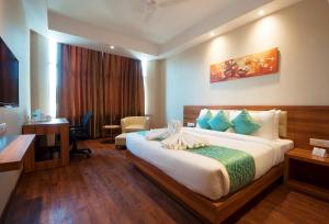 a hotel room with a large bed and a desk at Hotel Le Roi,Haridwar@Har Ki Pauri in Haridwār