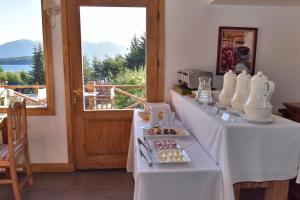 uma mesa com comida numa sala com uma janela em Hosteria Puertas Del Sol by Visionnaire em Villa La Angostura