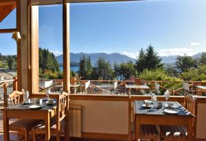 2 mesas en un balcón con vistas a las montañas en Hosteria Puertas Del Sol by Visionnaire en Villa La Angostura