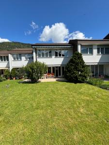 a large white house with a large yard at Garden Park Apartment in Interlaken