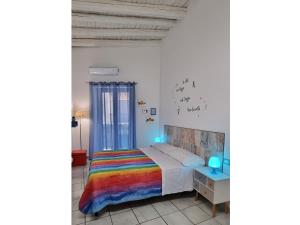 een slaapkamer met een bed met een regenboog deken bij Arco del Sole in Palermo