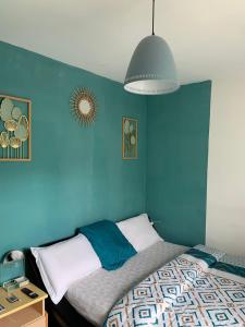 - une chambre avec un mur bleu et un lit dans l'établissement Chambre double à 10 minutes de Paris, à Antony
