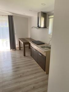 a kitchen with a table and a sink in it at Atskiri apartamentai in Šilutė
