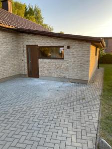a brick building with a door and a patio at Atskiri apartamentai in Šilutė