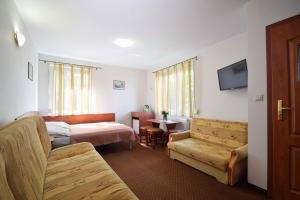 a hotel room with a bed and a couch at Villa del Marco in Rewal