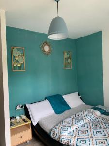 - une chambre dotée d'un mur bleu avec un lit et une table dans l'établissement Chambre double à 10 minutes de Paris, à Antony