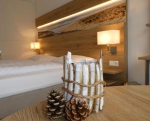 een slaapkamer met een bed en een tafel met dennenappels bij Strandhotel de Horn in Callantsoog