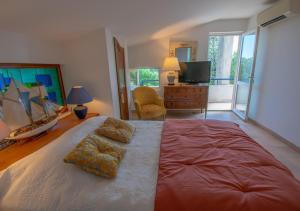 セイヤンにあるLe Mas de L'Ormeau, 130m2 Piscine, Parc, 8persの大きなベッドとテレビのある寝室