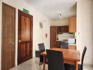 eine Küche und ein Esszimmer mit einem Holztisch und Stühlen in der Unterkunft Sea views apartment-wifi-sleep 5 in Marsaskala