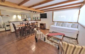 uma sala de estar com uma cama e uma sala de jantar em Cabañas Los Alamos by Visionnaire em San Martín de los Andes
