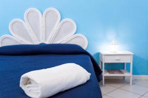 een blauwe slaapkamer met een bed met een handdoek erop bij Casa Angela Lipari in Canneto