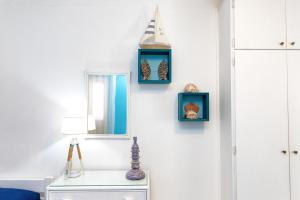 een kamer met drie blauwe lijsten aan een muur bij Casa Angela Lipari in Canneto