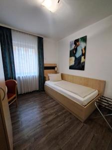 1 dormitorio con 1 cama y una pintura en la pared en Hotel Central Hauptbahnhof en Heidelberg
