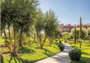 einen Weg durch einen Park mit Bäumen und einem Gebäude in der Unterkunft Vizir Appart 202 in Marrakesch