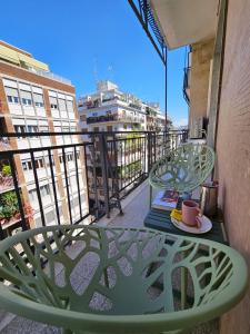 una mesa verde y una silla en un balcón con una taza de café en BariBello Apartment - 3 Bedrooms 3 Bathrooms - Bari Central Station, en Bari