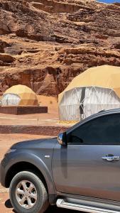 a car parked in front of a tent in the desert at Rum desert magic in Wadi Rum