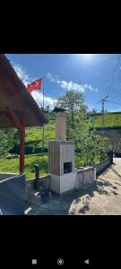 a brick fireplace with a flag in a field at Arslan KONAGI in Rize