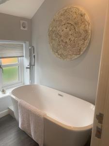 La salle de bains est pourvue d'une baignoire blanche et d'une fenêtre. dans l'établissement Country Cottage Barn Conversion, à Pollington