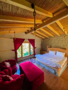 a bedroom with a bed and two red chairs at Kungrah Resort in Chamangul