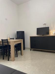 a dining room with a table and a tv at Rosa dei Venti in Polignano a Mare