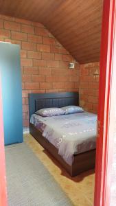 Un dormitorio con una cama en una pared de ladrillos. en Sevan - Lavanda Cottages, en Sevan