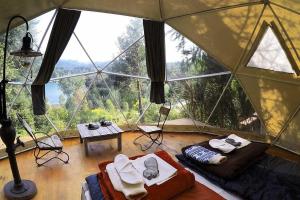 ビージャ・ラ・アンゴストゥーラにあるPuerto Manzano Suites by Visionnaireの大きな窓付きのテントが備わる客室です。