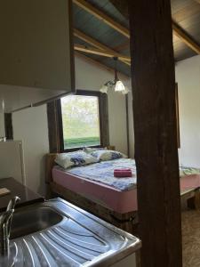 a kitchen with a bed in a room with a sink at Forest House Ninokristali in Visoko
