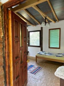a room with a door and a bed in it at Forest House Ninokristali in Visoko